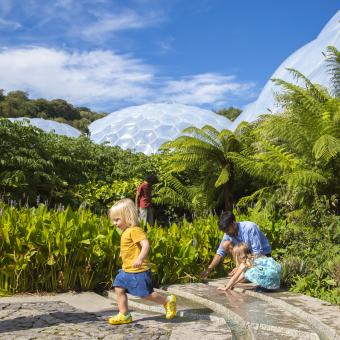 Young family playing in the outdoor gardens at the Eden Project